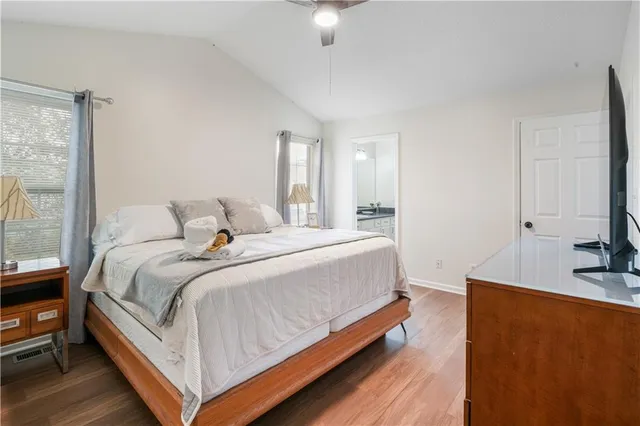 a bedroom with a bed and a flat tv screen on a dresser
