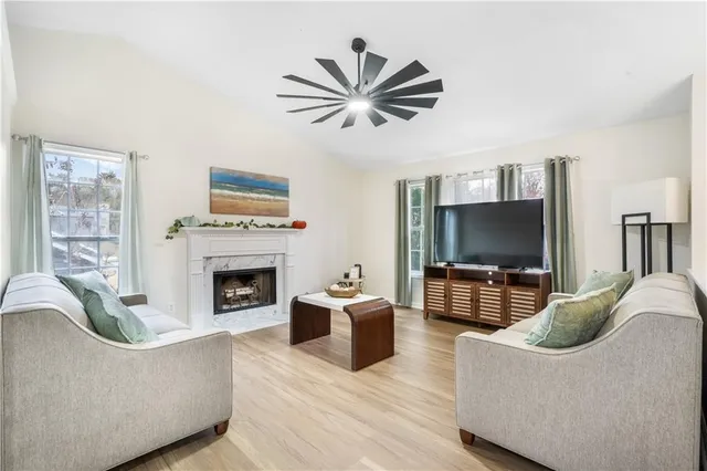a living room with furniture a flat screen tv and a fireplace