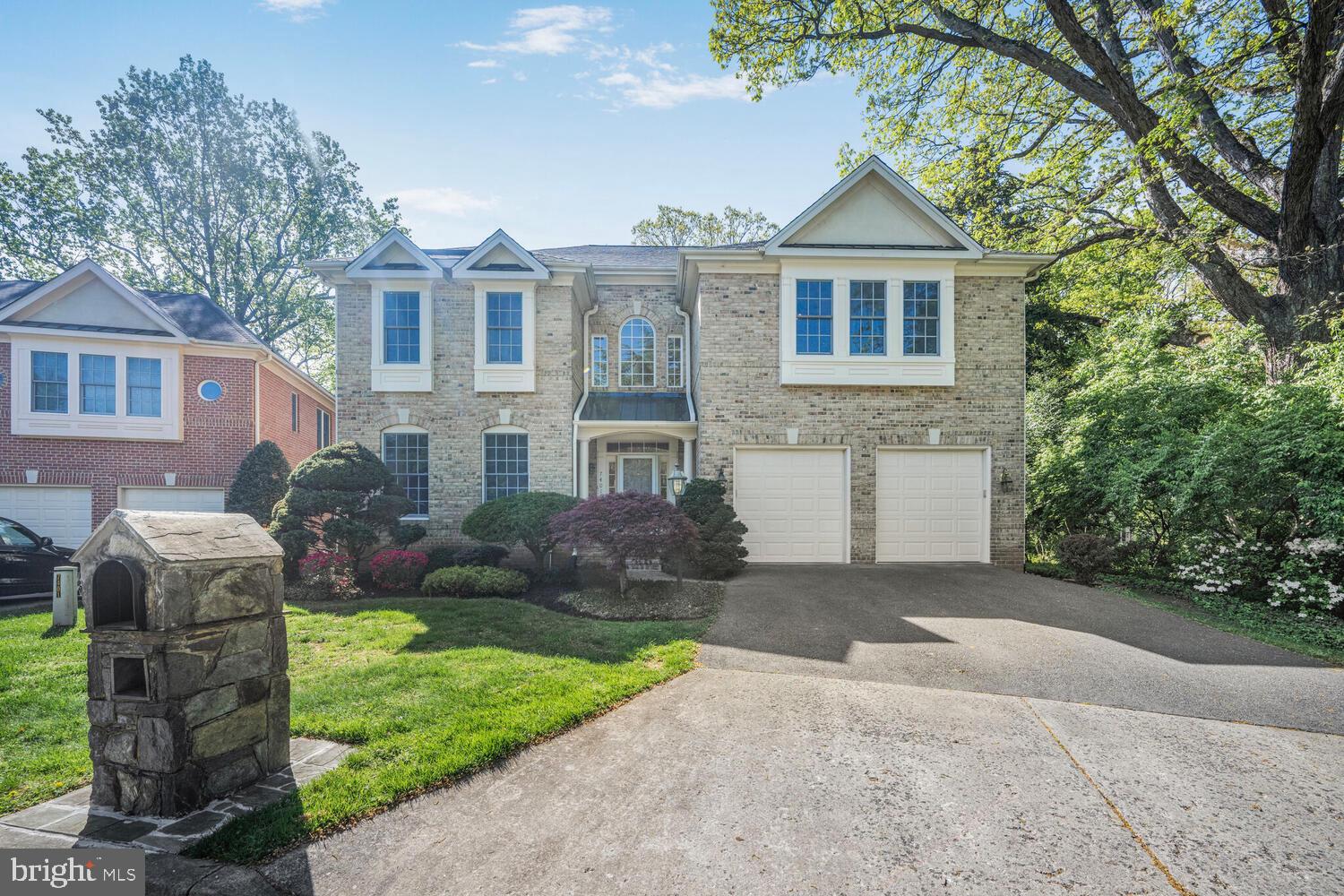 a front view of a house with a garden and trees