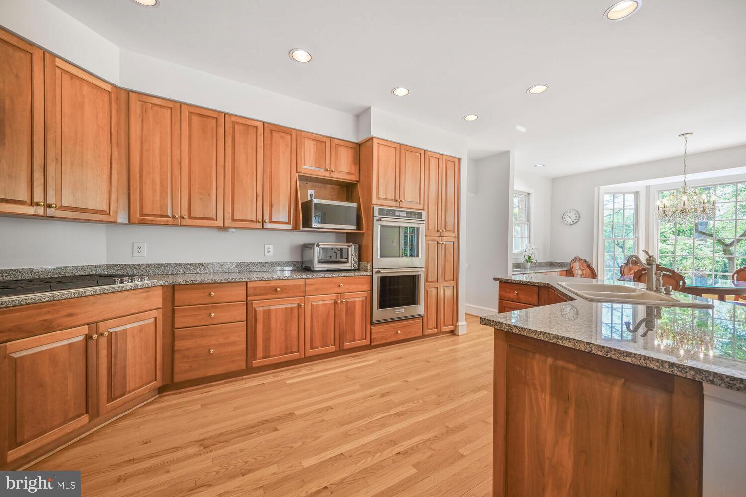 7401 Honesty Way Bethesda, MD 20817 - Photo 3 of 54 a kitchen with stainless steel appliances granite countertop wooden cabinets a sink and a large window