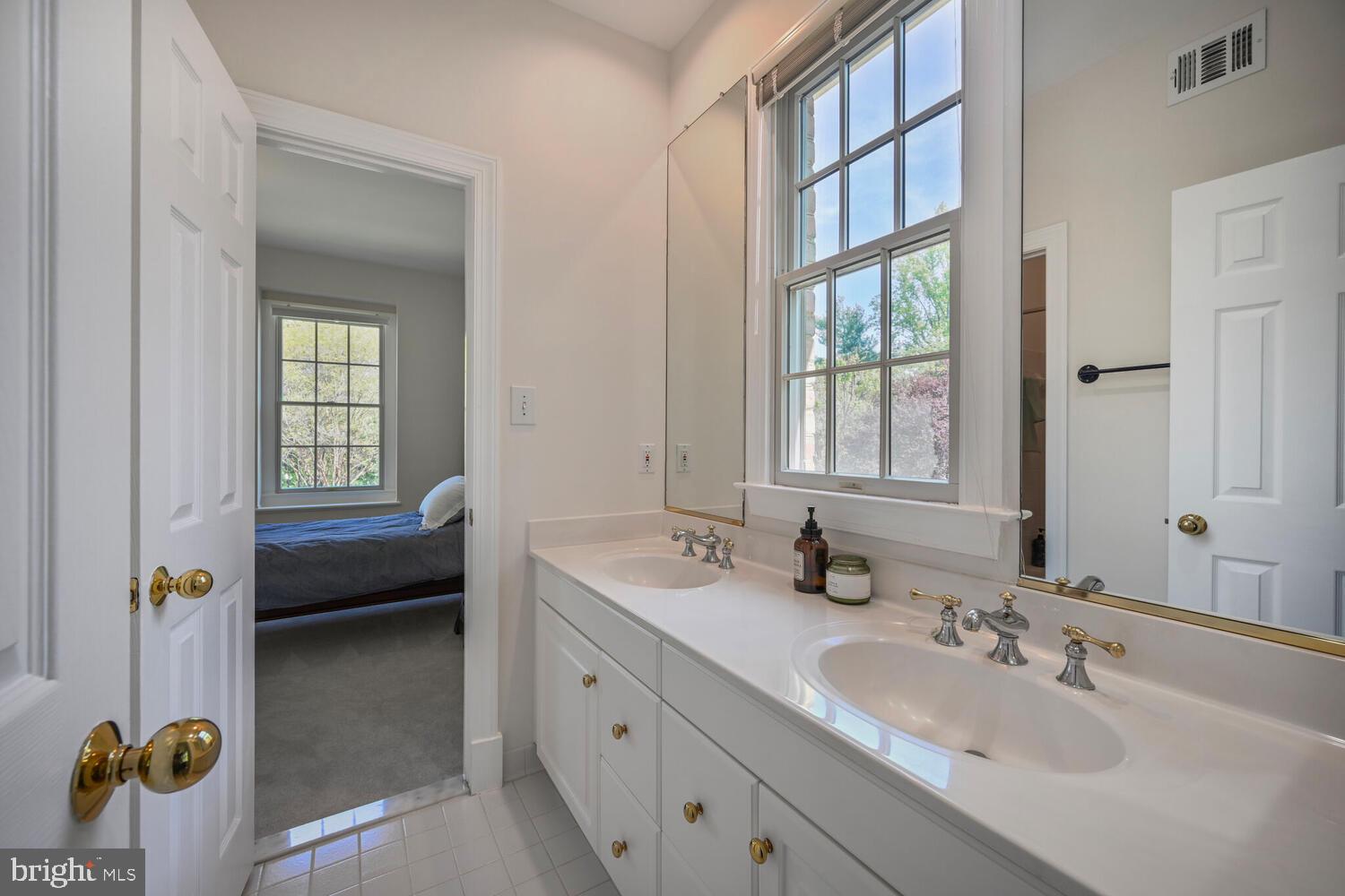 7401 Honesty Way Bethesda, MD 20817 - Photo 35 of 54 a en suite bathroom with a sink a window and mirror