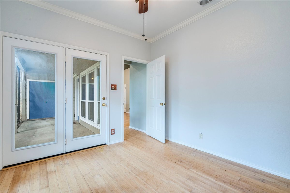 3809 Spicewood Springs Road, Unit 127 Austin, TX 78759 - Photo 21 of 29 French doors open to an exterior area from this naturally lit room with wood flooring.