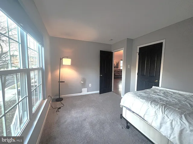 a spacious bedroom with a bed and a large window