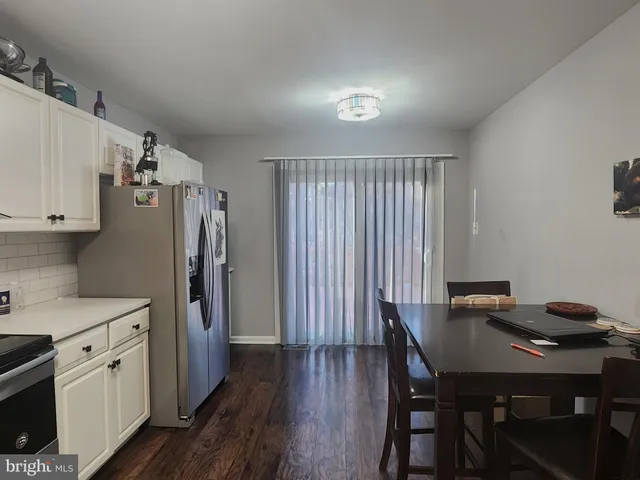 a kitchen with stainless steel appliances a table chairs and a refrigerator