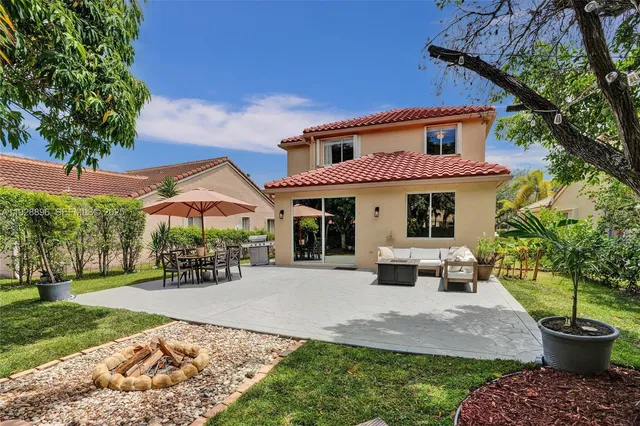 a front view of a house with a yard garden and outdoor seating
