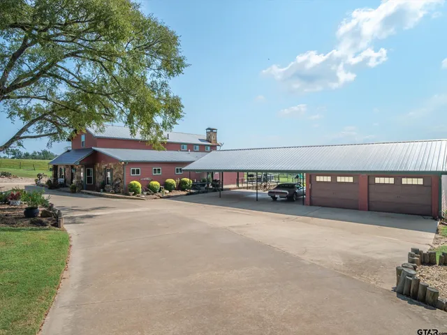 a view of a house with a patio and a yard