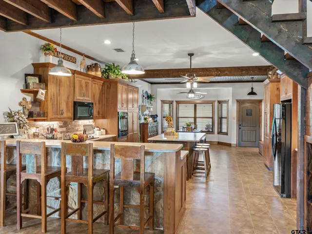 a dining table with chairs and kitchen view