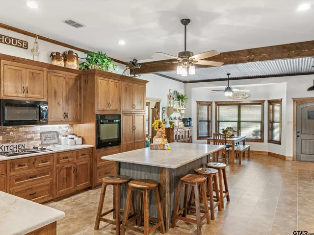 a kitchen with stainless steel appliances granite countertop a stove and a wooden cabinets