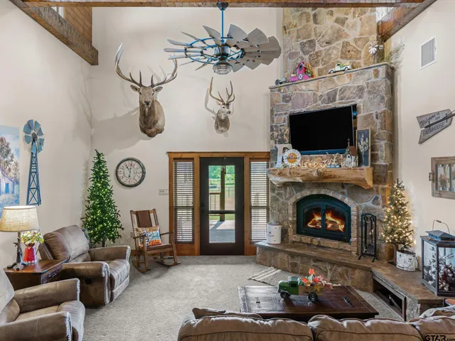 a living room with furniture a fireplace and a chandelier