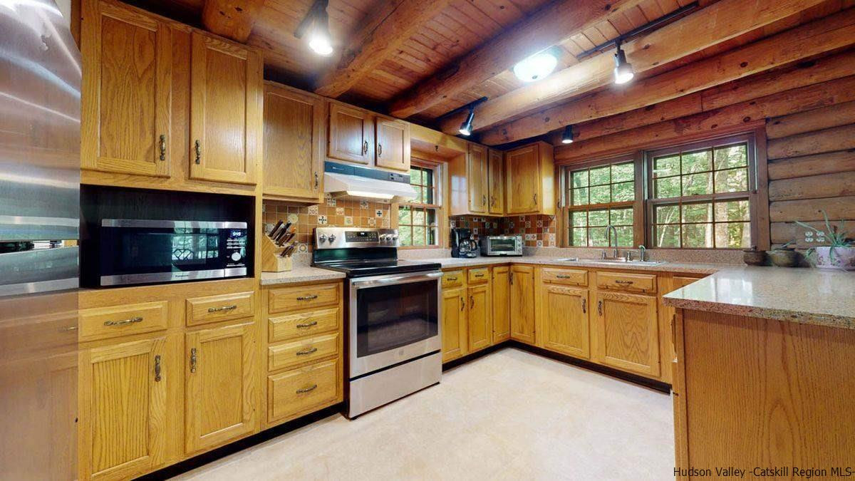 296 Bush Road Stone Ridge, NY 12484 - Photo 15 of 27 a kitchen with granite countertop wooden cabinets a sink a stove and a refrigerator