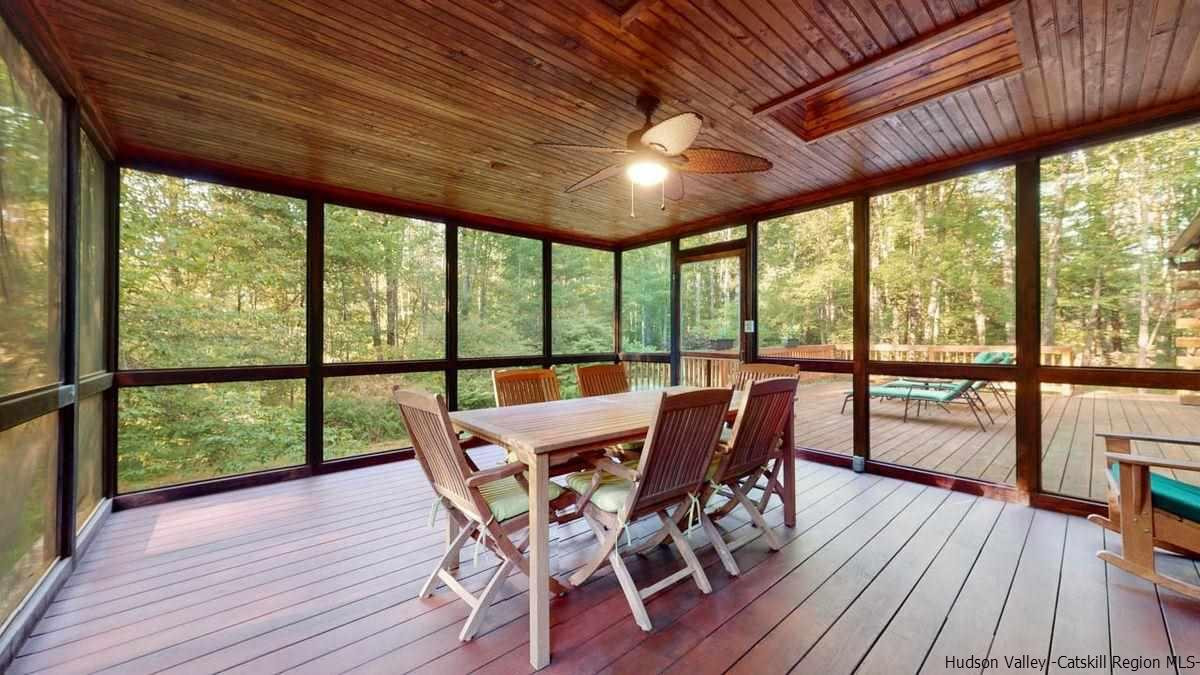 296 Bush Road Stone Ridge, NY 12484 - Photo 9 of 27 a view of a dining room with furniture large windows and wooden floor