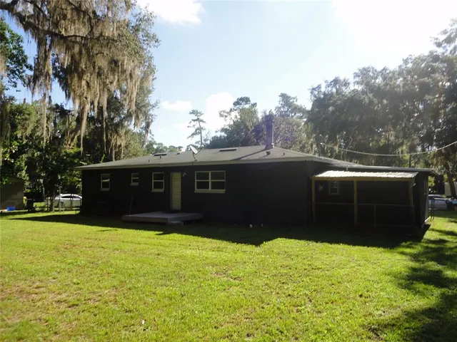 a view of house with yard and a garden