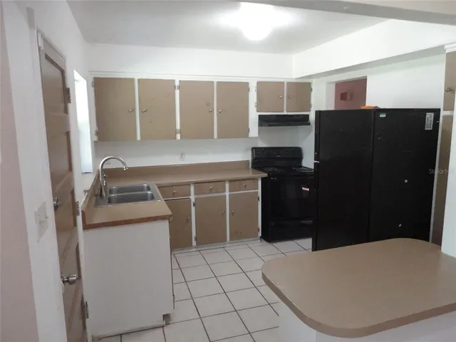 a kitchen with a refrigerator and a sink