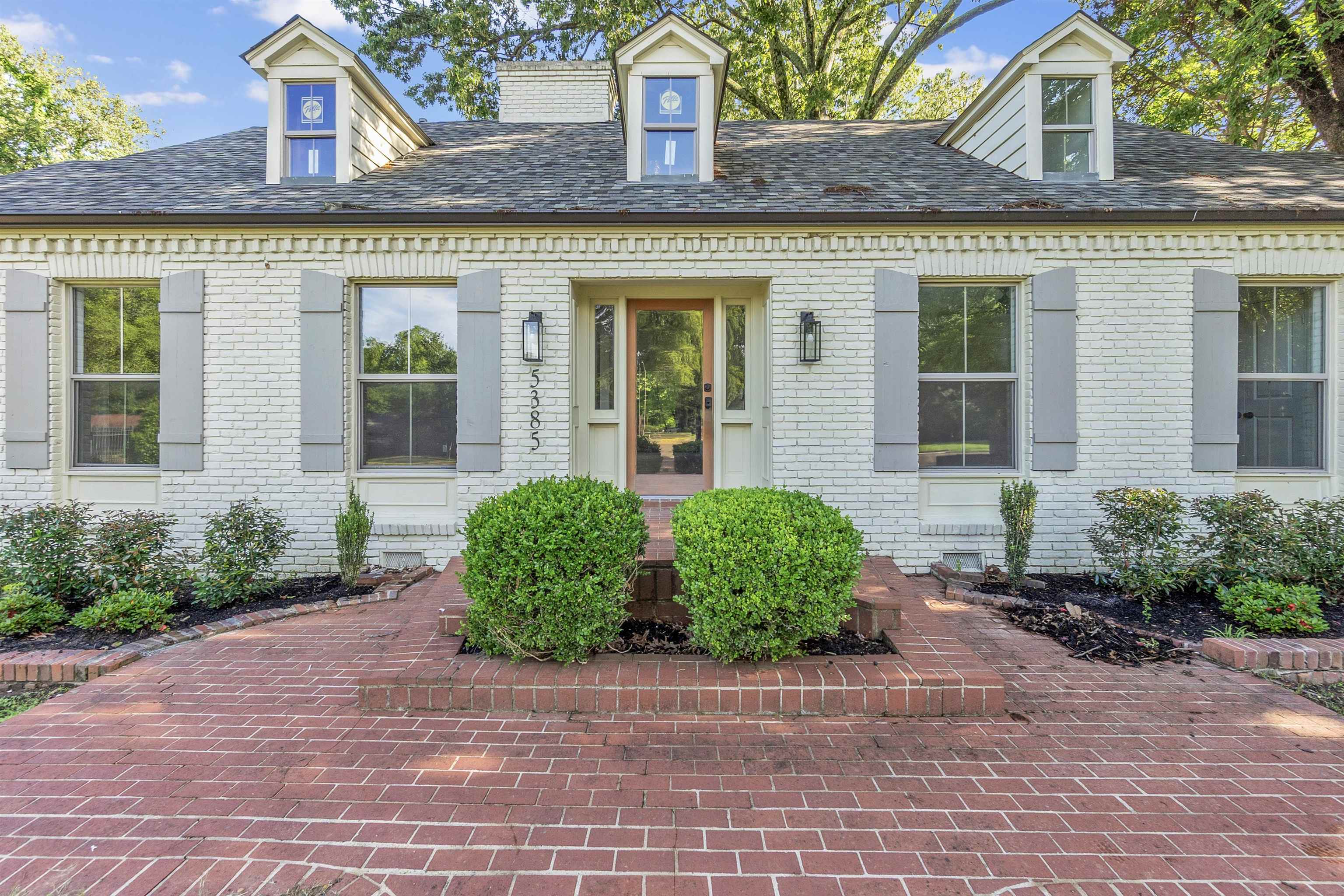front view of a brick house with a small yard
