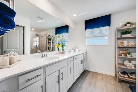 a bathroom with a double vanity sink and a mirror