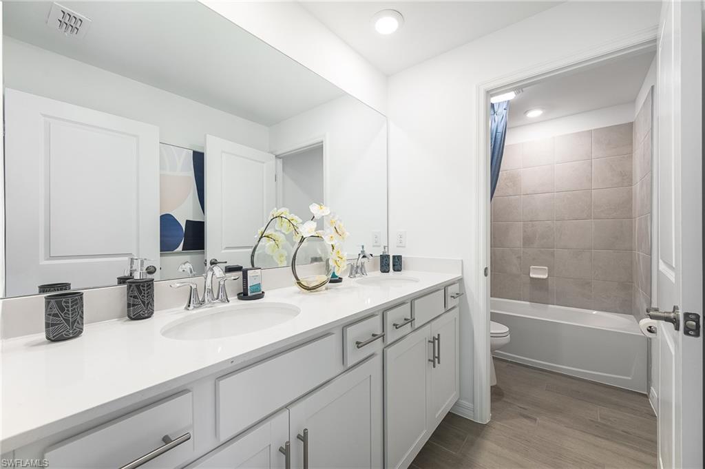 2318 Avocado Lane Naples, FL 34120 - Photo 25 of 47 a bathroom with double vanity sink a mirror and a shower
