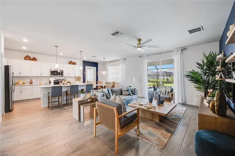 a living room with furniture kitchen view and a potted plant