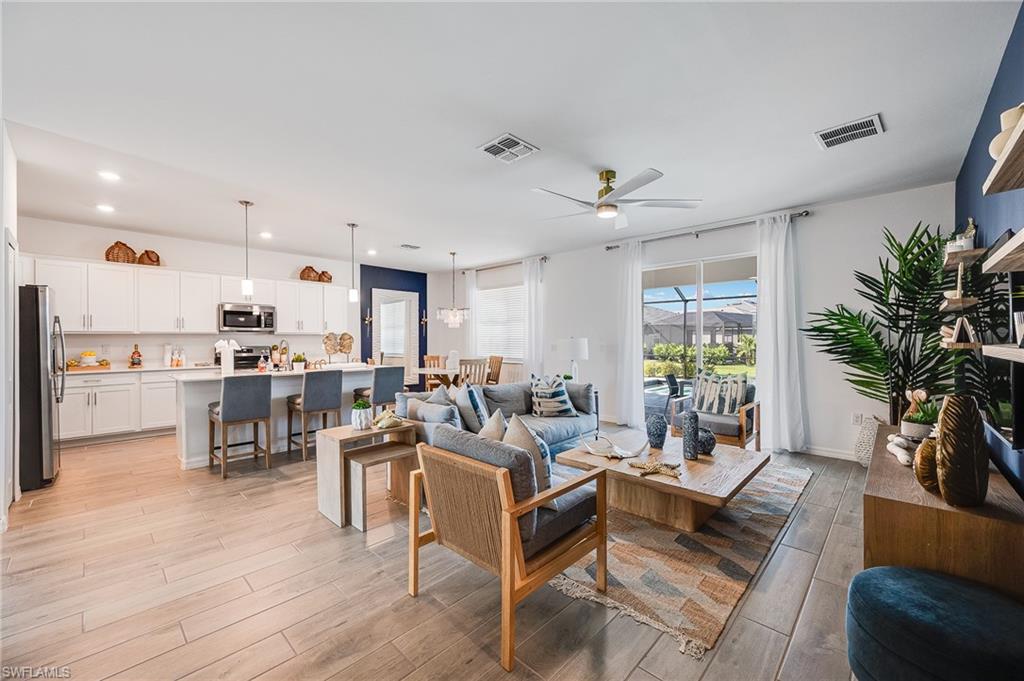 2318 Avocado Lane Naples, FL 34120 - Photo 3 of 47 a living room with furniture kitchen view and a potted plant