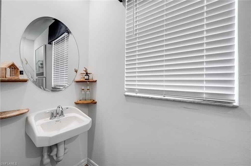 2318 Avocado Lane Naples, FL 34120 - Photo 38 of 47 a bathroom with a sink a mirror and a shower