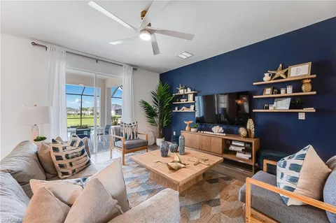 a living room with furniture a bookshelf and a flat screen tv