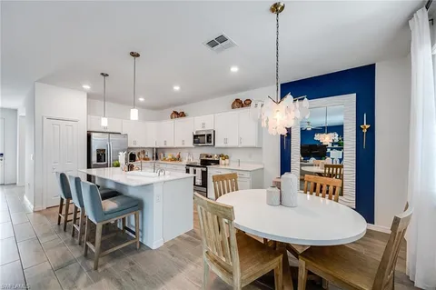 a kitchen with kitchen island a dining table and chairs