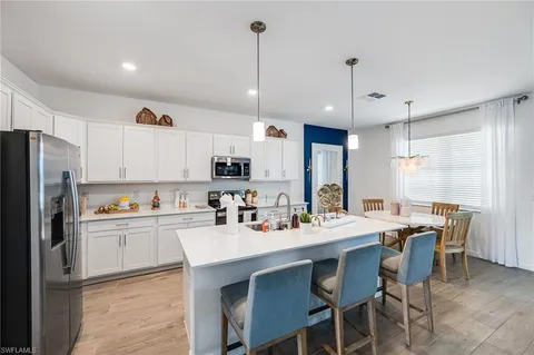 a kitchen with refrigerator cabinets dining table and chairs