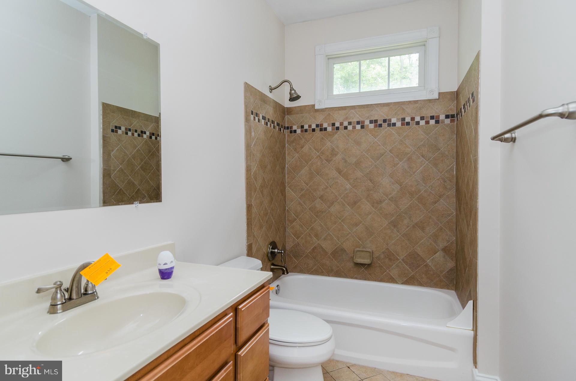 3902 Goose Harbor Road Middle River, MD 21220 - Photo 18 of 30 a bathroom with a granite countertop bathtub shower sink vanity mirror and toilet