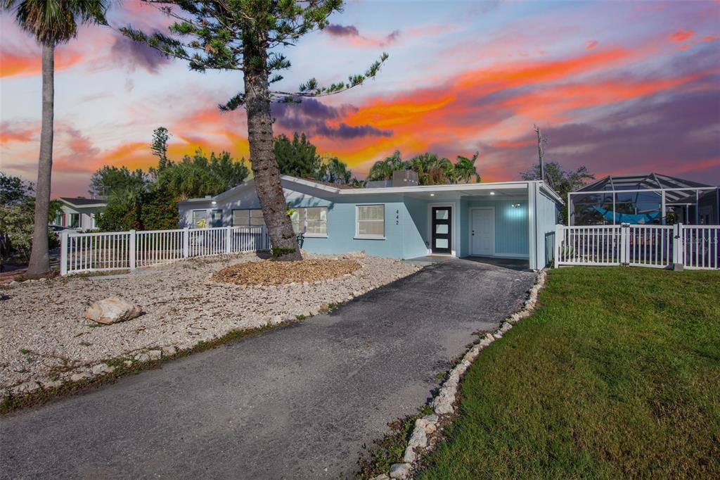 a front view of a house with a yard and potted plants