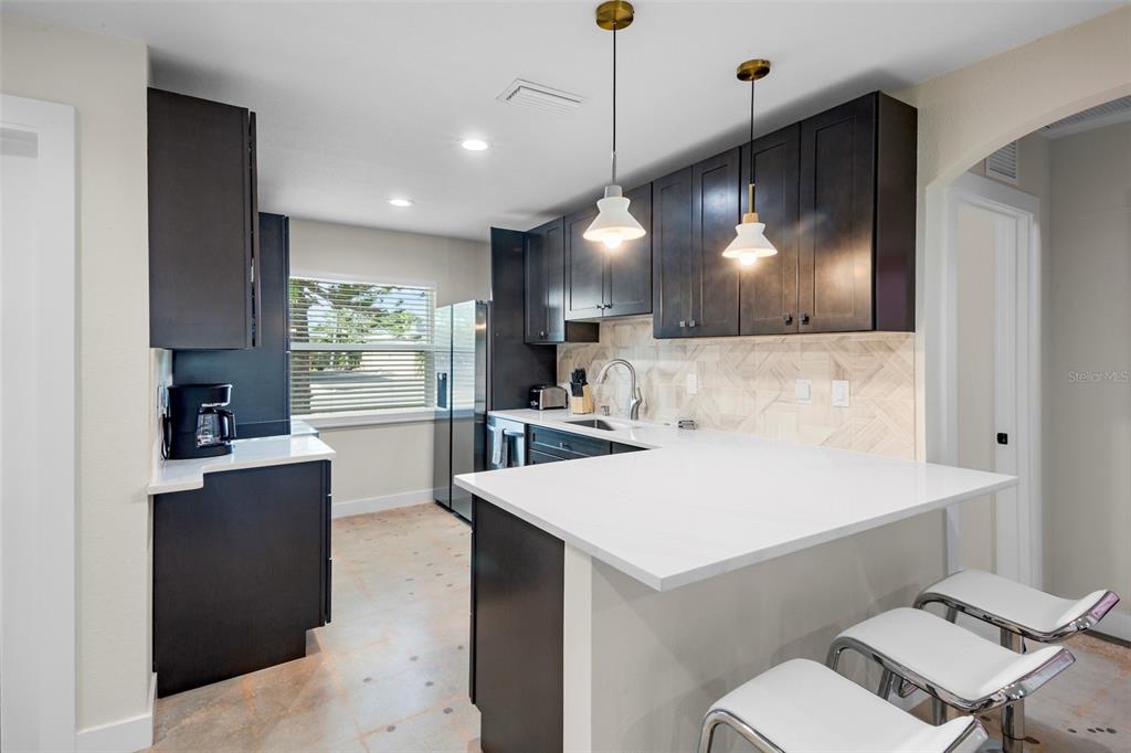 442 62nd Street Holmes Beach, FL 34217 - Photo 5 of 29 a view of kitchen with kitchen island a stove a refrigerator a sink and a living room view