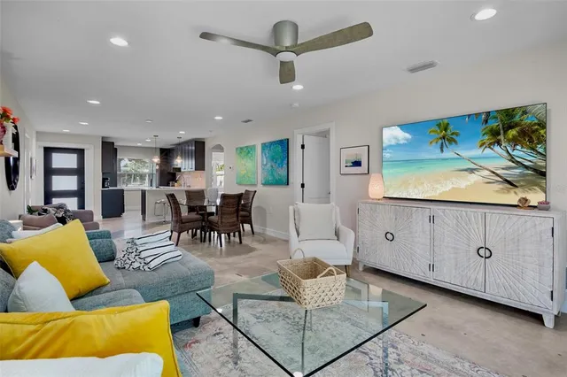 a living room with furniture kitchen view and a flat screen tv