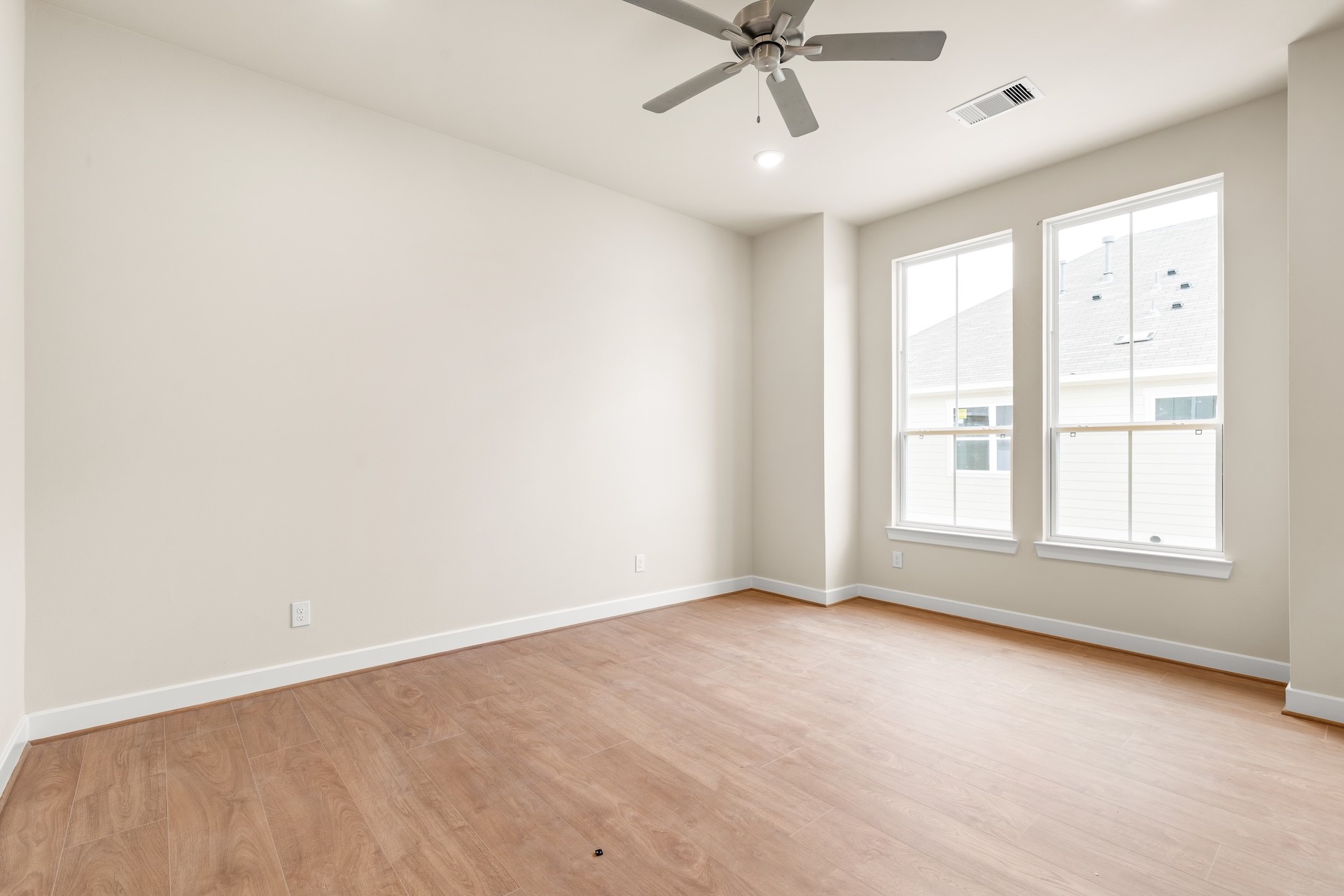 6521 Rena Street Houston, TX 77092 - Photo 11 of 24 Light and airy guest room — dual sash windows bringing in natural sunlight, modern ceiling fan, and neutral paint palette.