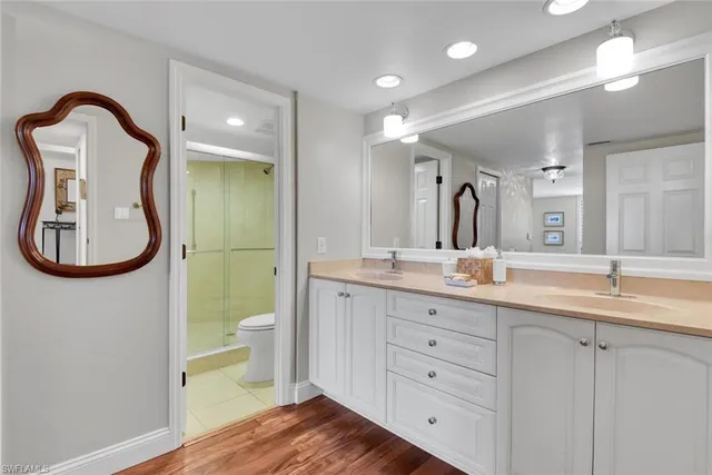 a spacious bathroom with a granite countertop toilet sink and mirror