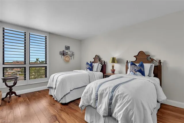 a bedroom with two beds and a large window