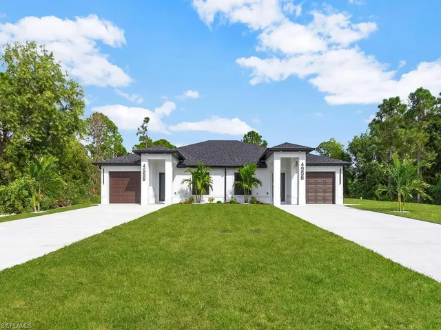 a front view of a house with a garden and yard