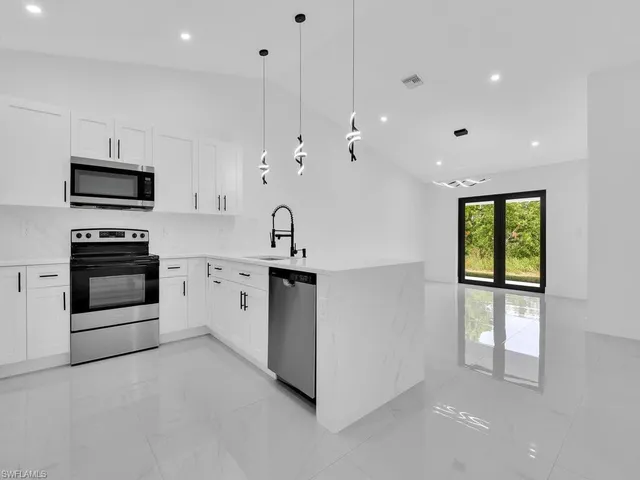 a kitchen with stainless steel appliances kitchen island granite countertop a stove a sink and a microwave