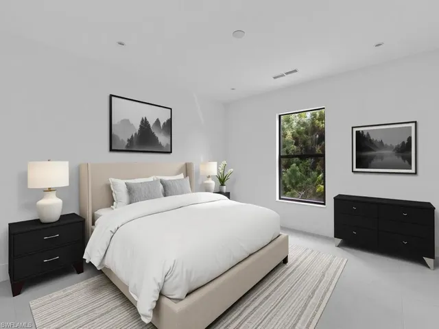 a bedroom with a bed and a lamp on dresser