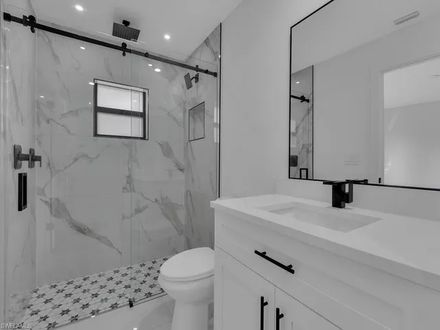a bathroom with a sink toilet a mirror and shower