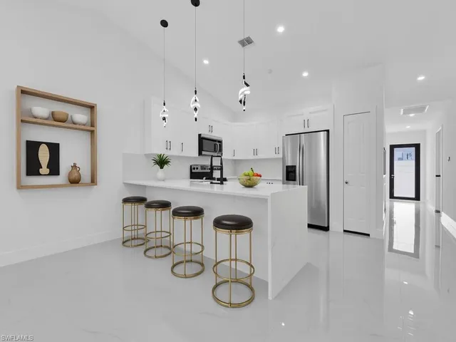 a kitchen with white cabinets and refrigerator