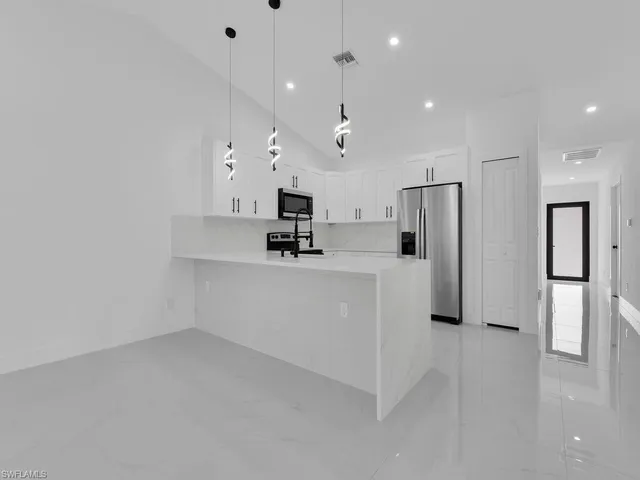 a kitchen with stainless steel appliances a refrigerator and a stove top oven