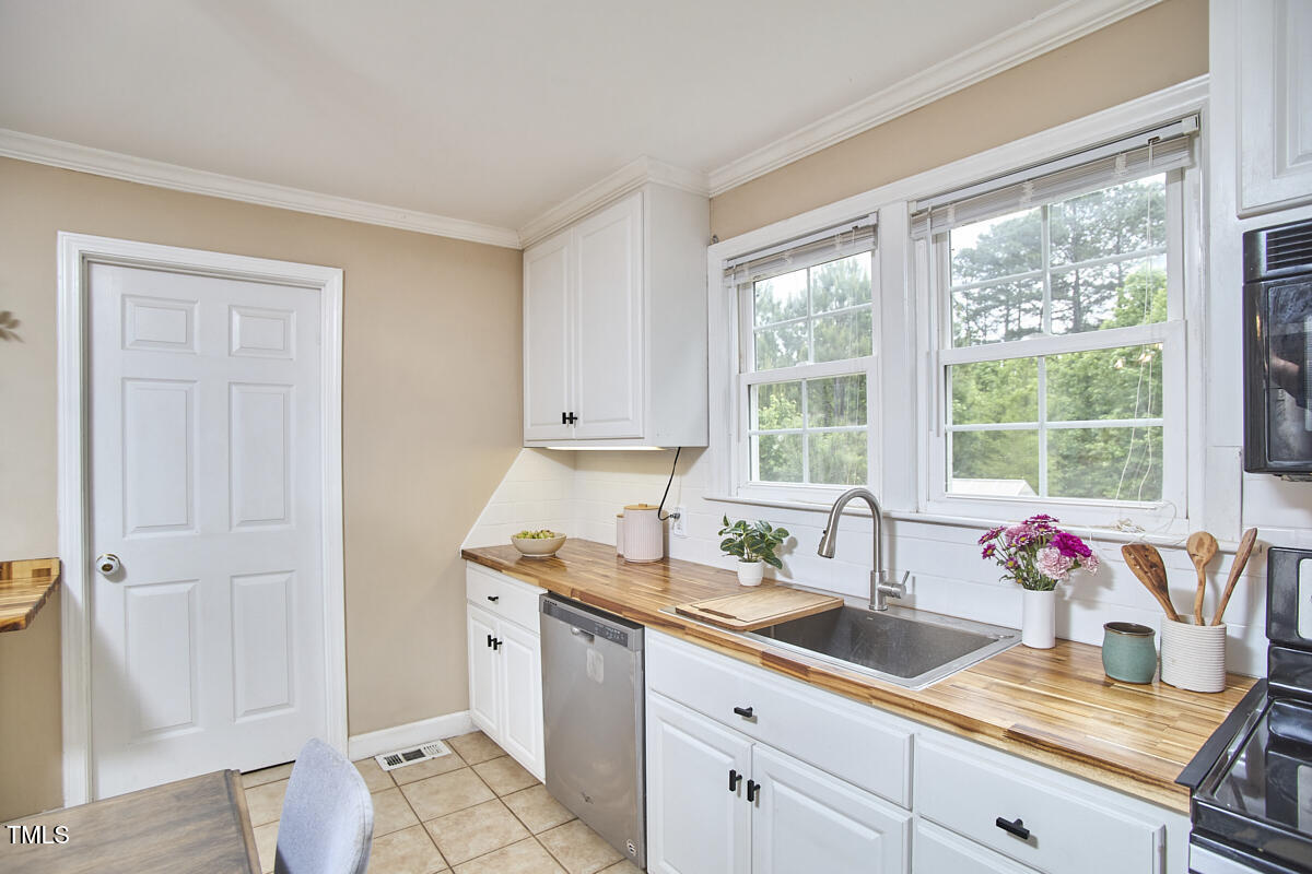 909 Goodwin Road Durham, NC 27712 - Photo 12 of 52 a kitchen with a sink refrigerator and window