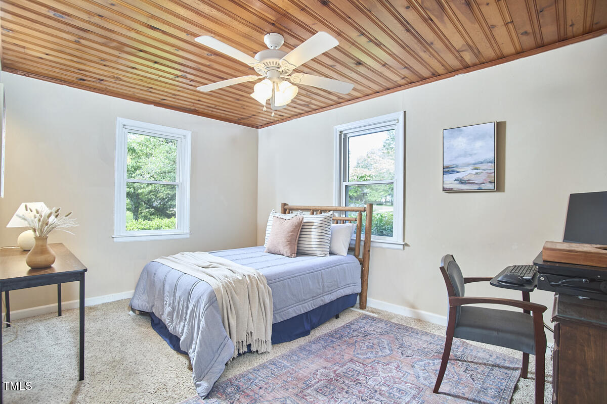 909 Goodwin Road Durham, NC 27712 - Photo 15 of 52 a bedroom with a bed a chair and a large window