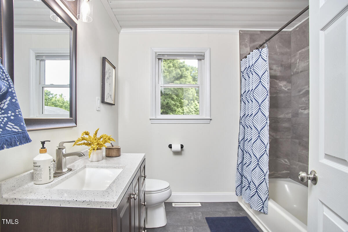 909 Goodwin Road Durham, NC 27712 - Photo 18 of 52 a bathroom with a sink toilet and window