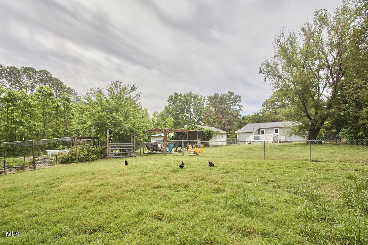909 Goodwin Road Durham, NC 27712 - Photo 26 of 52 a view of an house with a big yard and large trees