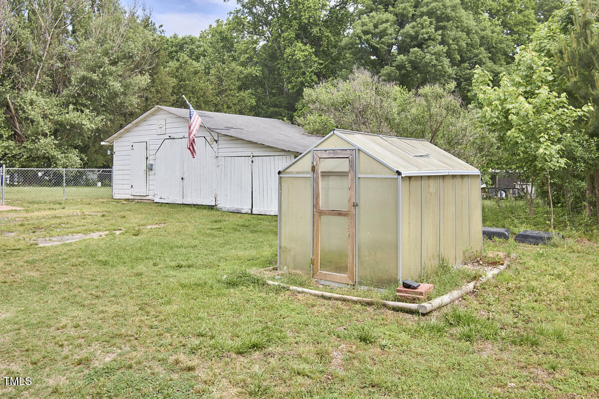 909 Goodwin Road Durham, NC 27712 - Photo 43 of 52 a view of a tiny house with a yard and large tree