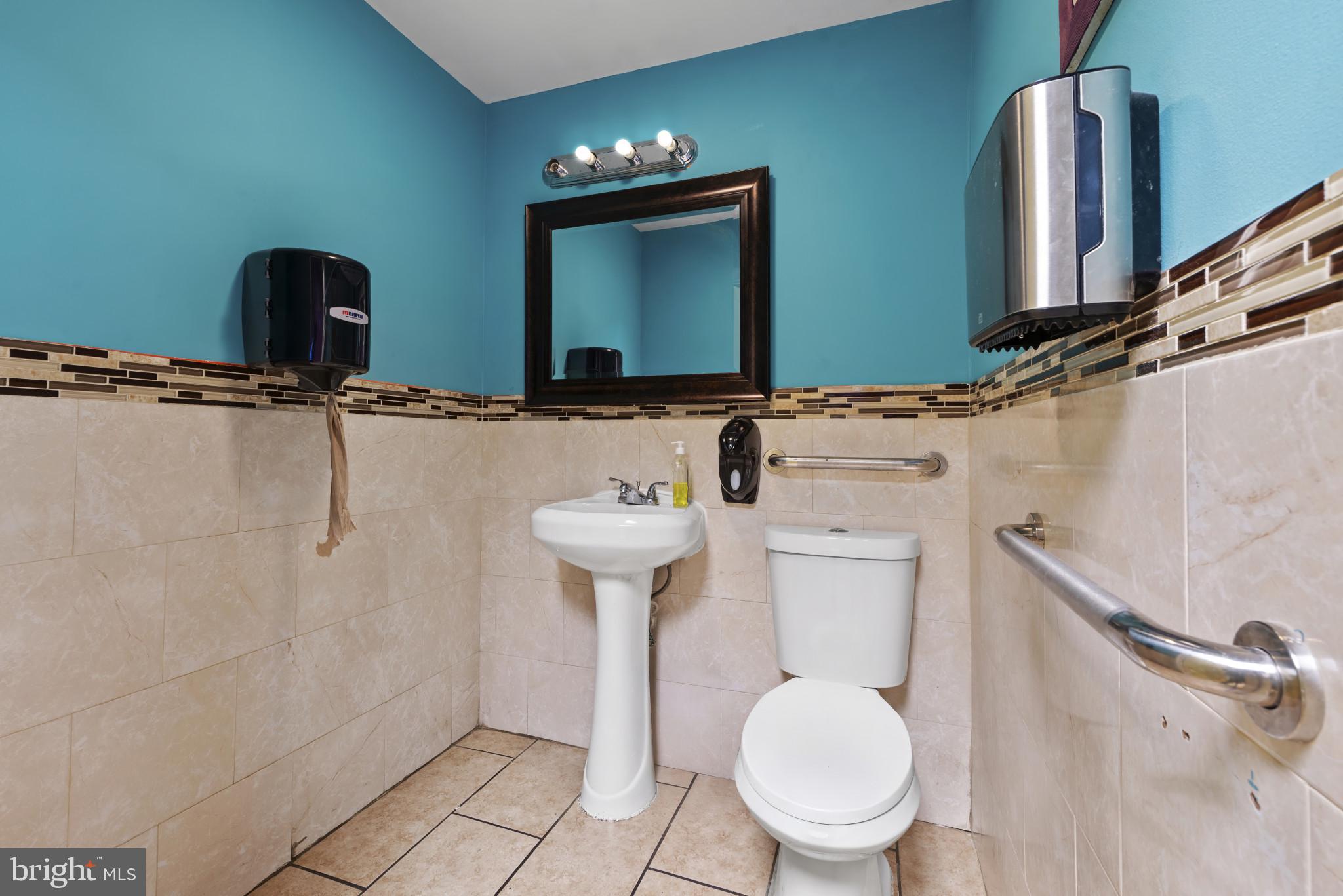 3418 Eastern Avenue Baltimore, MD 21224 - Photo 35 of 53 a bathroom with a toilet sink and mirror