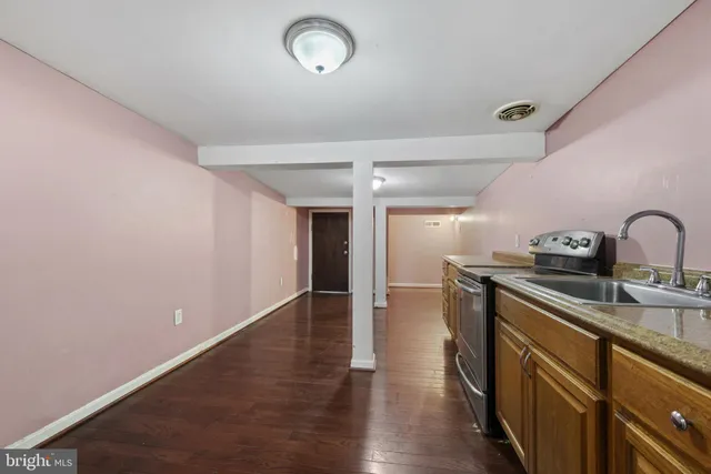 a view of an empty room with wooden floor and closet