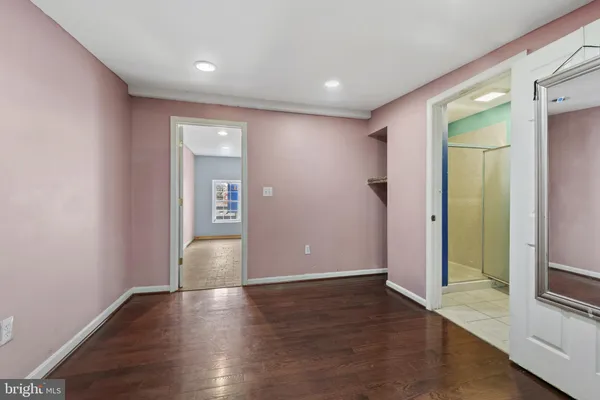 an empty room with wooden floor and entrance