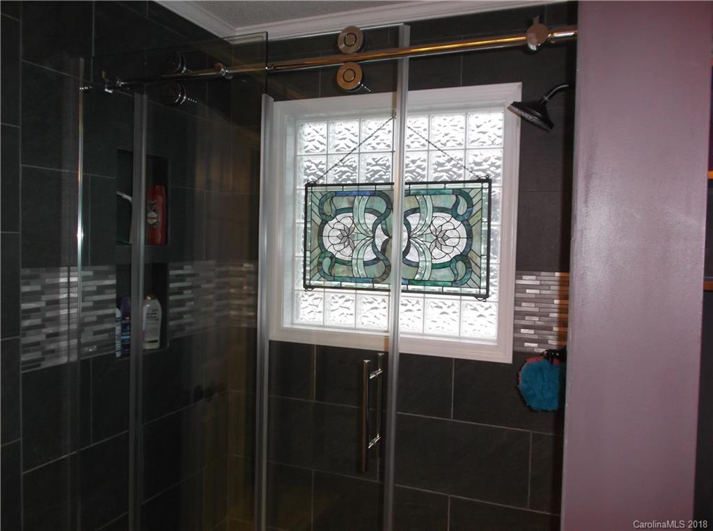 136 Maple Ridge Circle Salisbury, NC 28147 - Photo 14 of 23 a bathroom with a glass shower door and a window