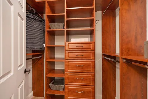 a view of walk in closet with clothes