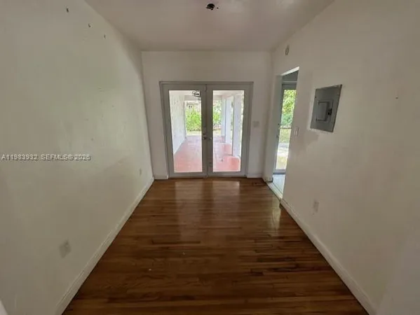 a view of a hallway with wooden floor and stairs